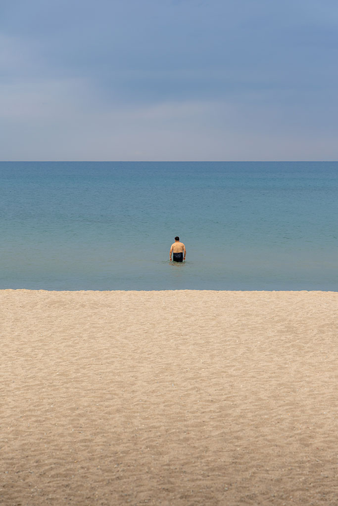 Portretfoto van een eenzame lokale man in het Issyk-Kul-meer in Kirgizië door reisfotograaf Moments by Mark.