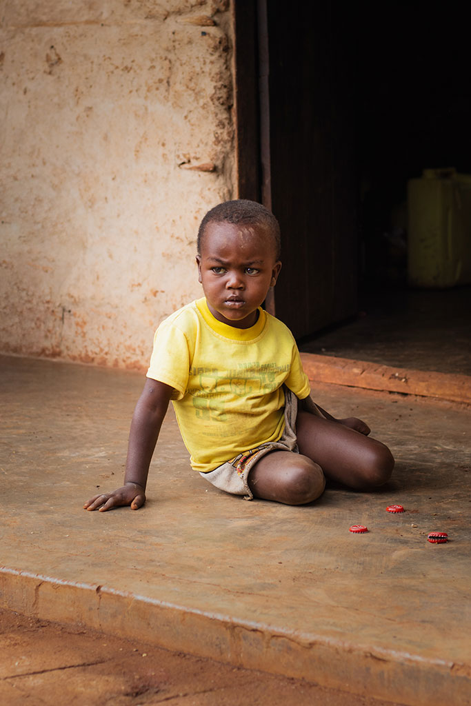 Portret van een jongen die speelt met dopjes in Sipi Falls, Oeganda, door Moments by Mark.