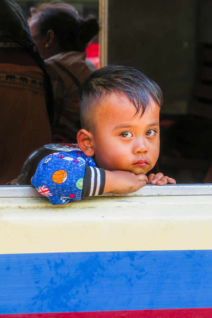 Portret van een jongen in de trein in Myanmar, gemaakt door portretfotograaf Moments by Mark.